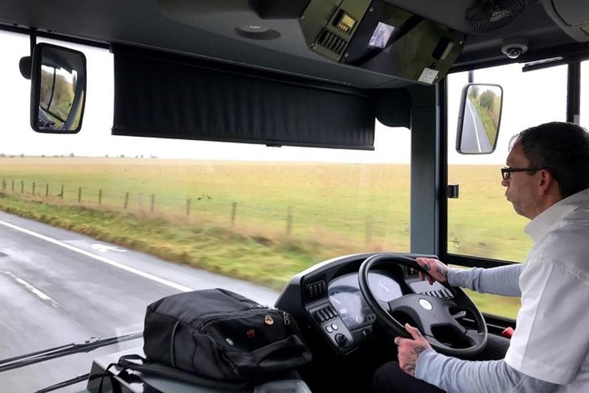 muž řídící autobus na silnici