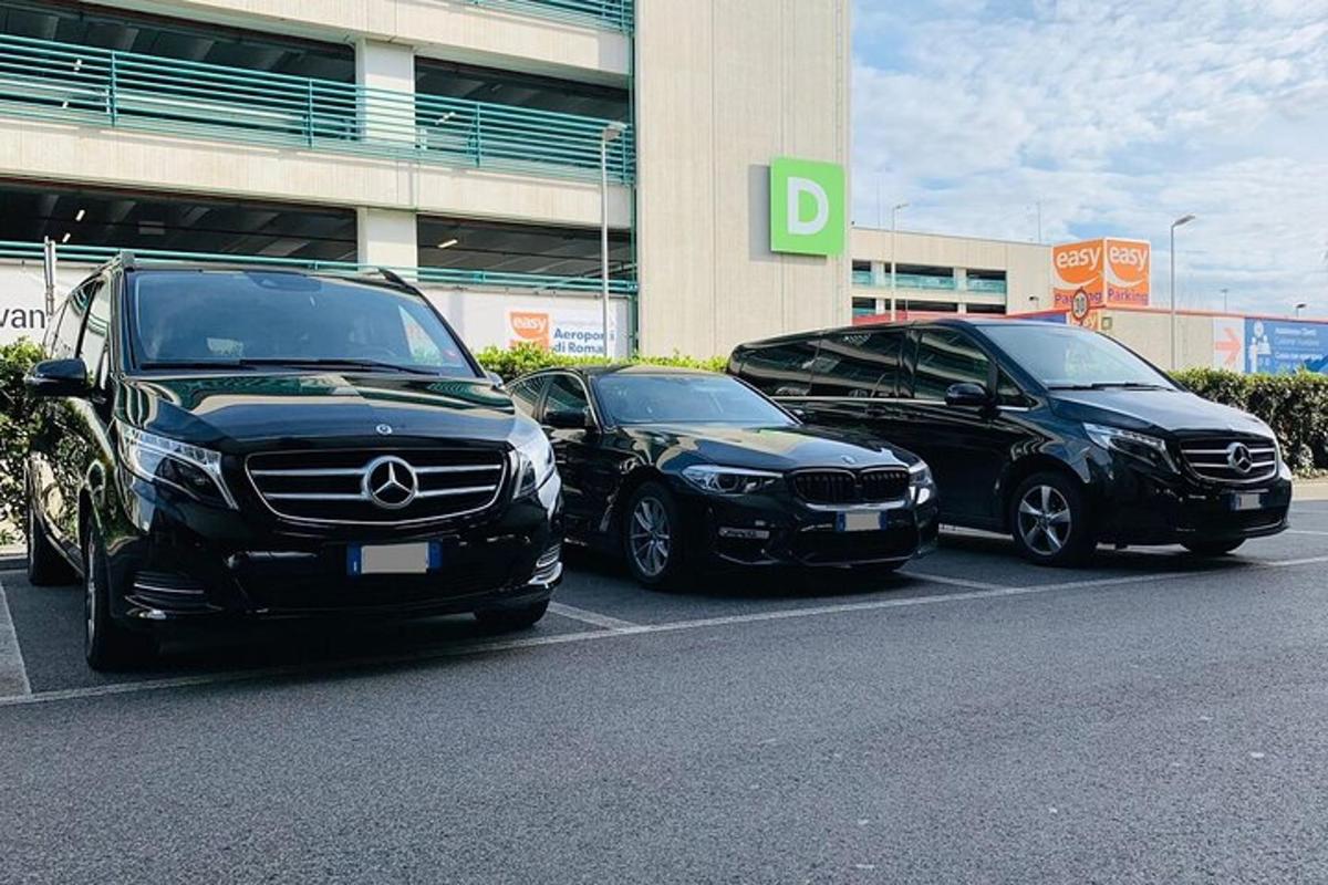 tři auta zaparkovaná na parkovišti před budovou