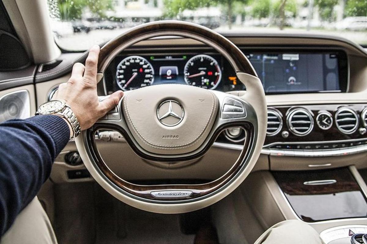 un uomo alla guida di un'auto con la mano sul volante