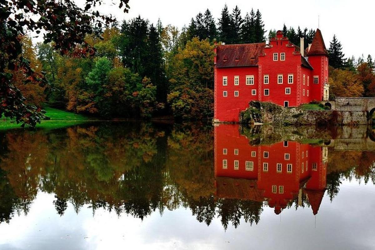 un grande edificio rosso con il suo riflesso nell'acqua