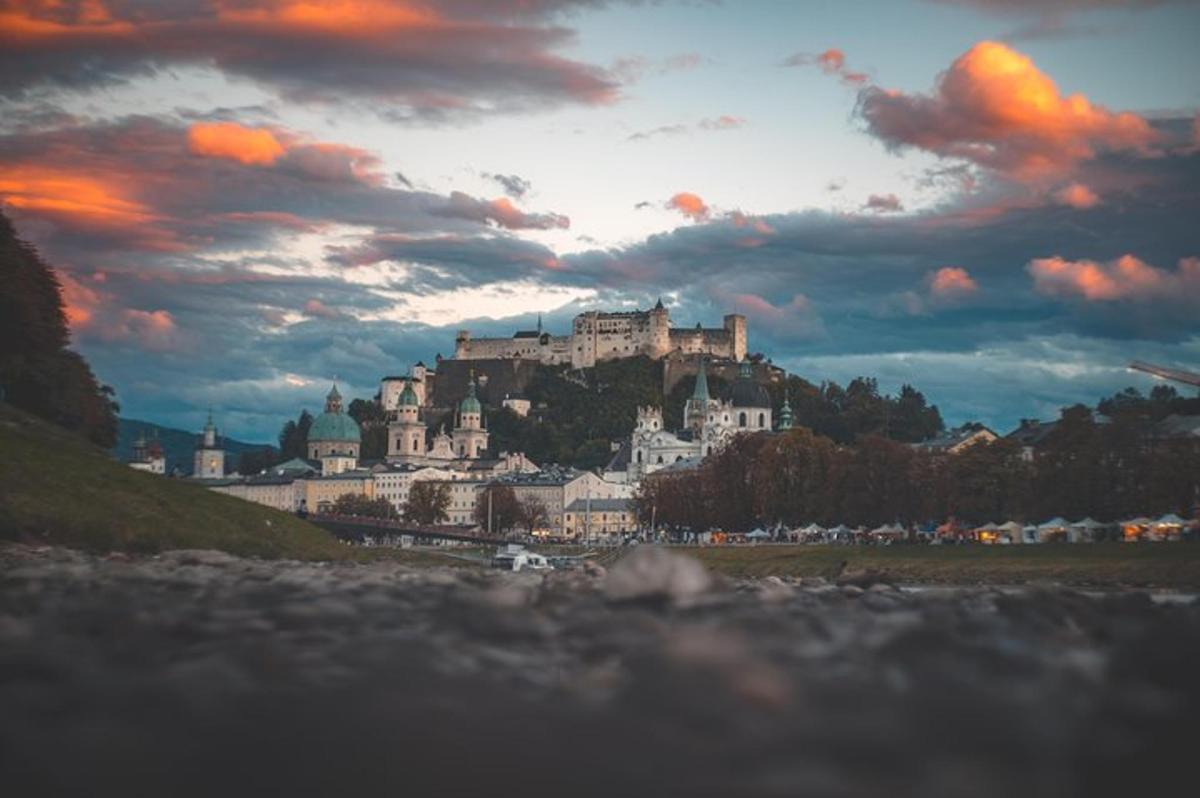 un grand château au sommet d'une colline sous un ciel nuageux