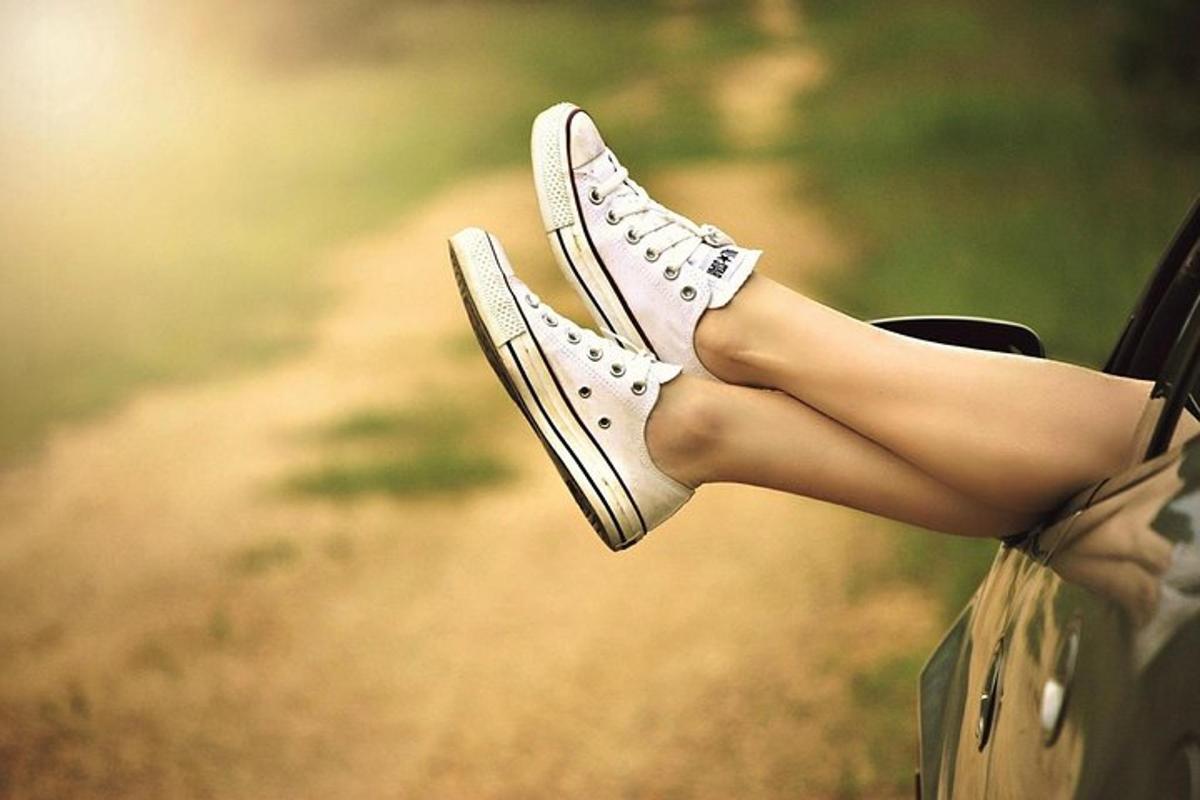 Una mujer con las piernas fuera de un par de zapatos.