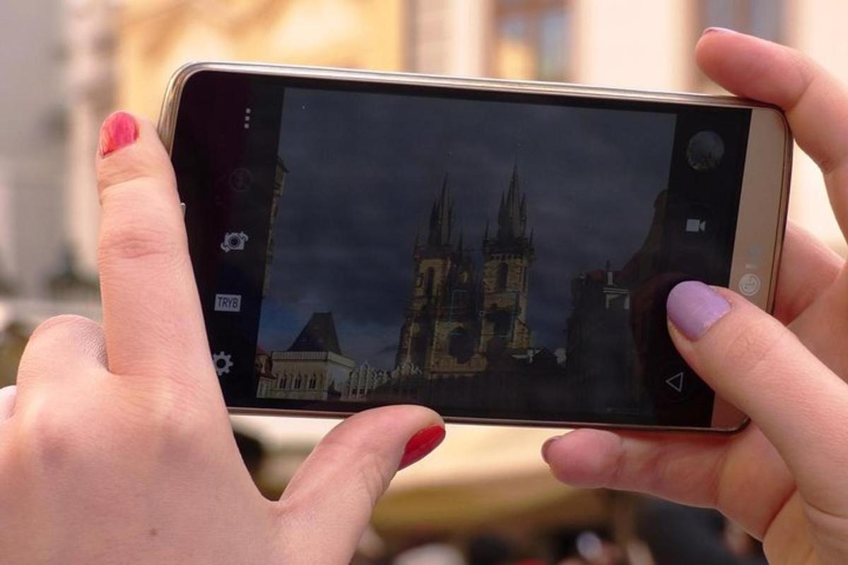 osoba koja fotografira dvorac mobitelom