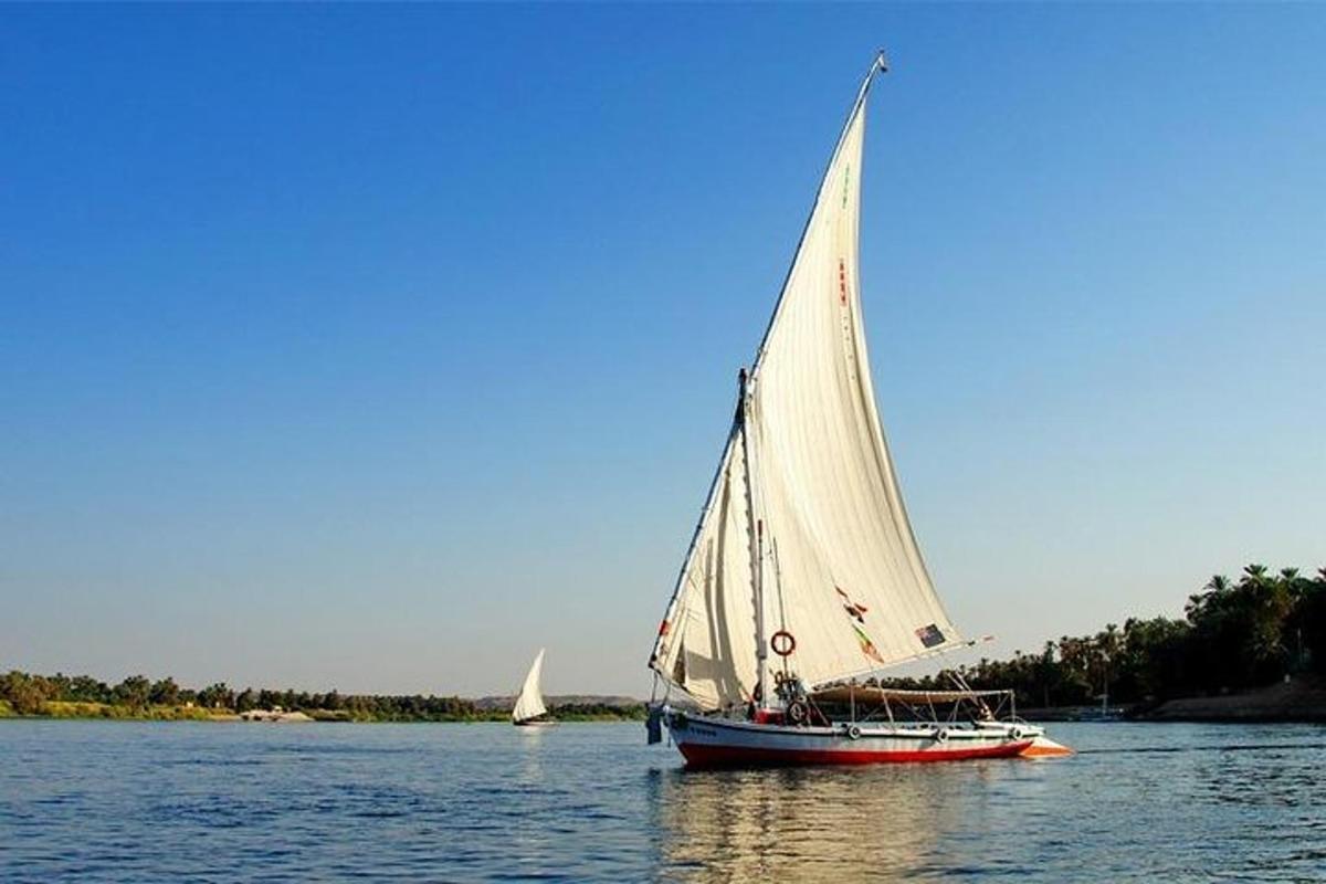 um barco com uma vela branca na água