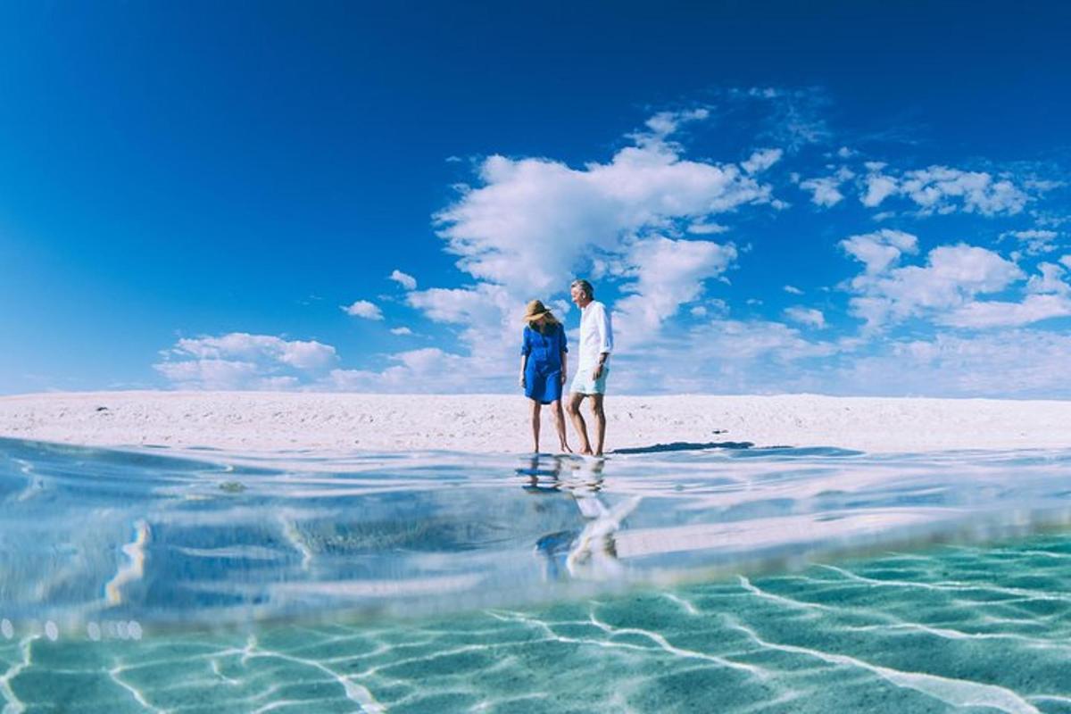 een stel staand in het water op het strand