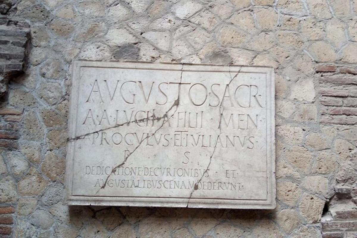 un cartello sul lato di un muro di pietra