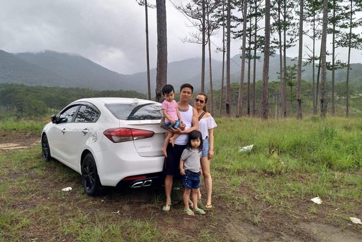 Una familia parada frente a un auto blanco