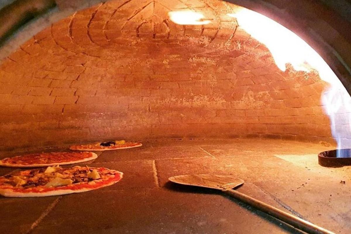 Un horno de pizza con tres pizzas dentro