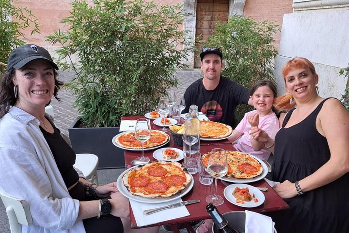 um grupo de pessoas sentadas à mesa com pizza