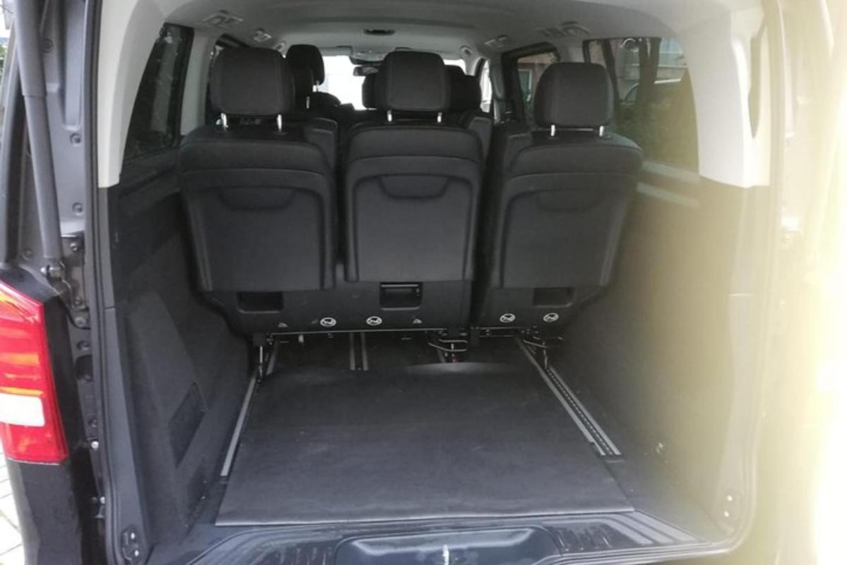 an open trunk of a car with the back doors open