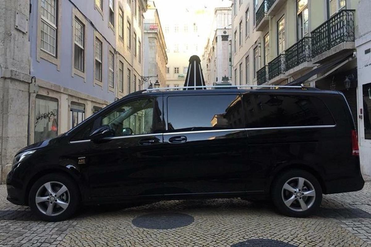 un furgone nero parcheggiato su una strada con un ombrello