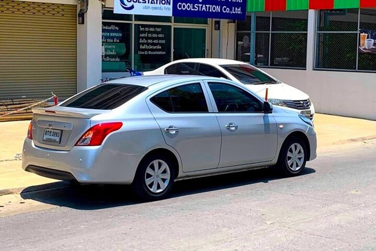 isang silver na kotse ang nakaparada sa gilid ng isang kalye
