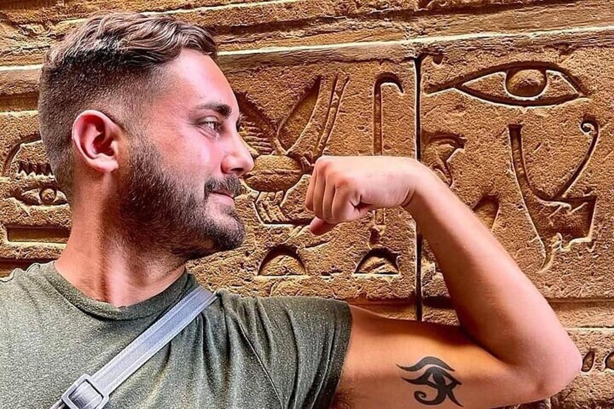 en mand stående foran en stenmur