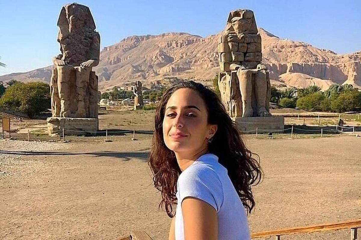 a woman standing in front of a statue