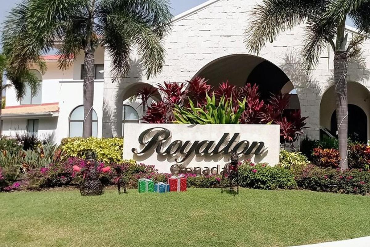 a sign in front of a resort with palm trees
