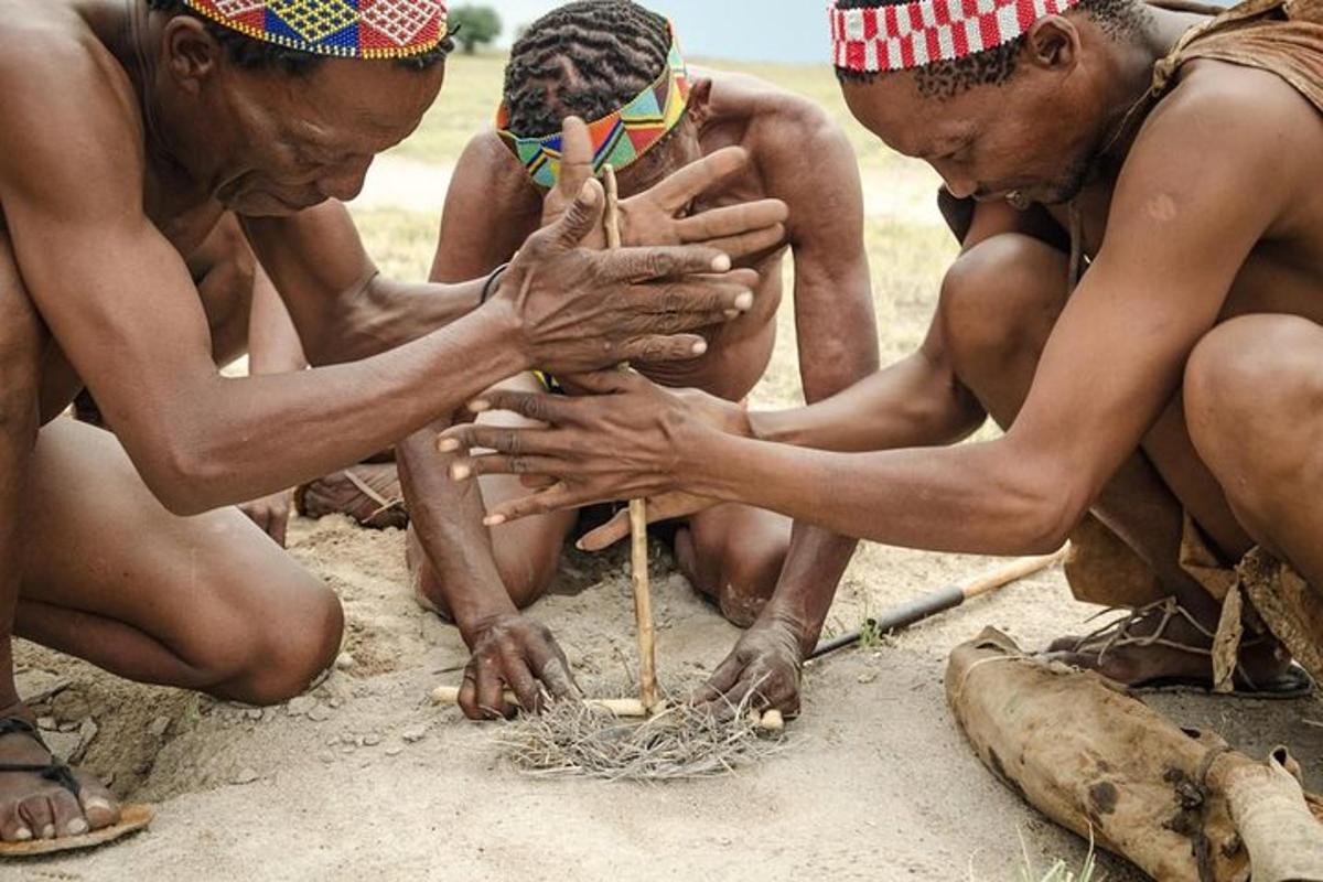 a group of men playing in the sand with sticks