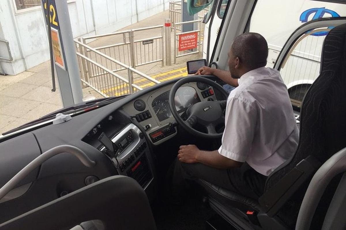 muž sedící na sedadle řidiče autobusu
