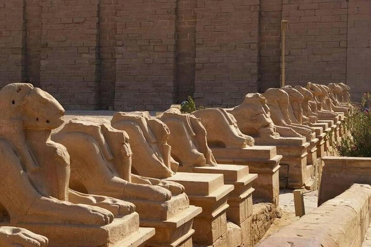 Una fila de estatuas de piedra sentadas junto a un edificio.