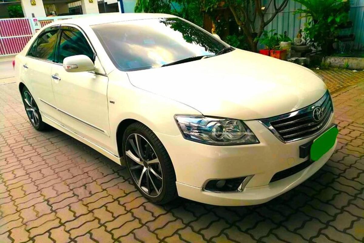 un'auto bianca parcheggiata su una strada di mattoni