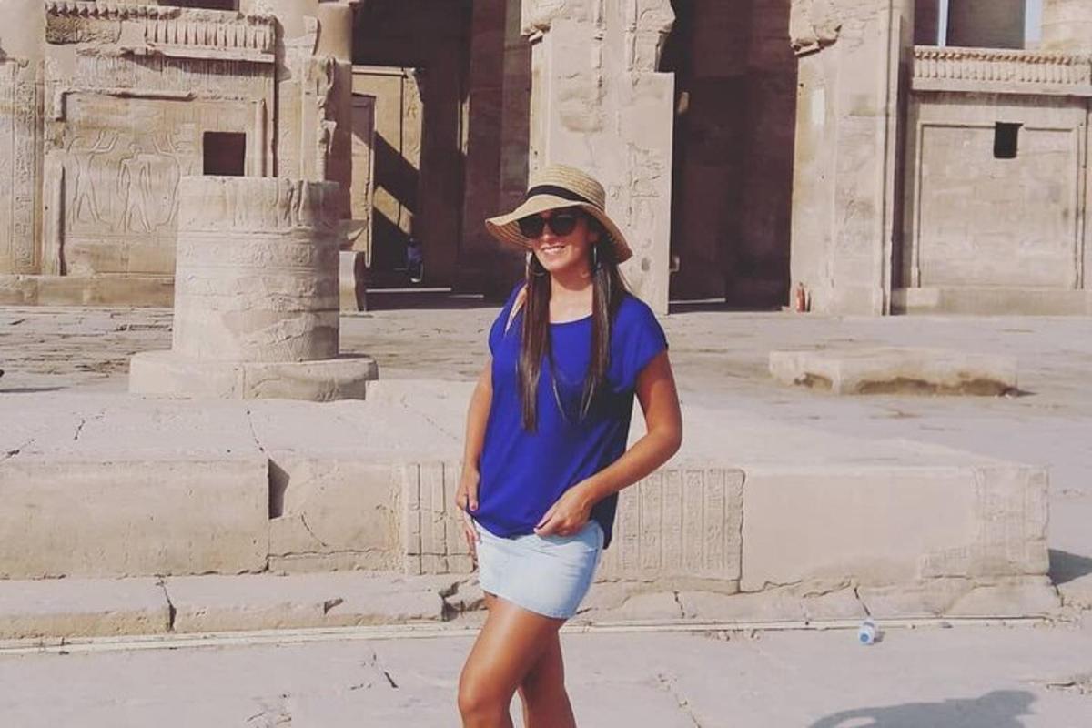 una donna con una maglietta blu e pantaloncini davanti a un edificio