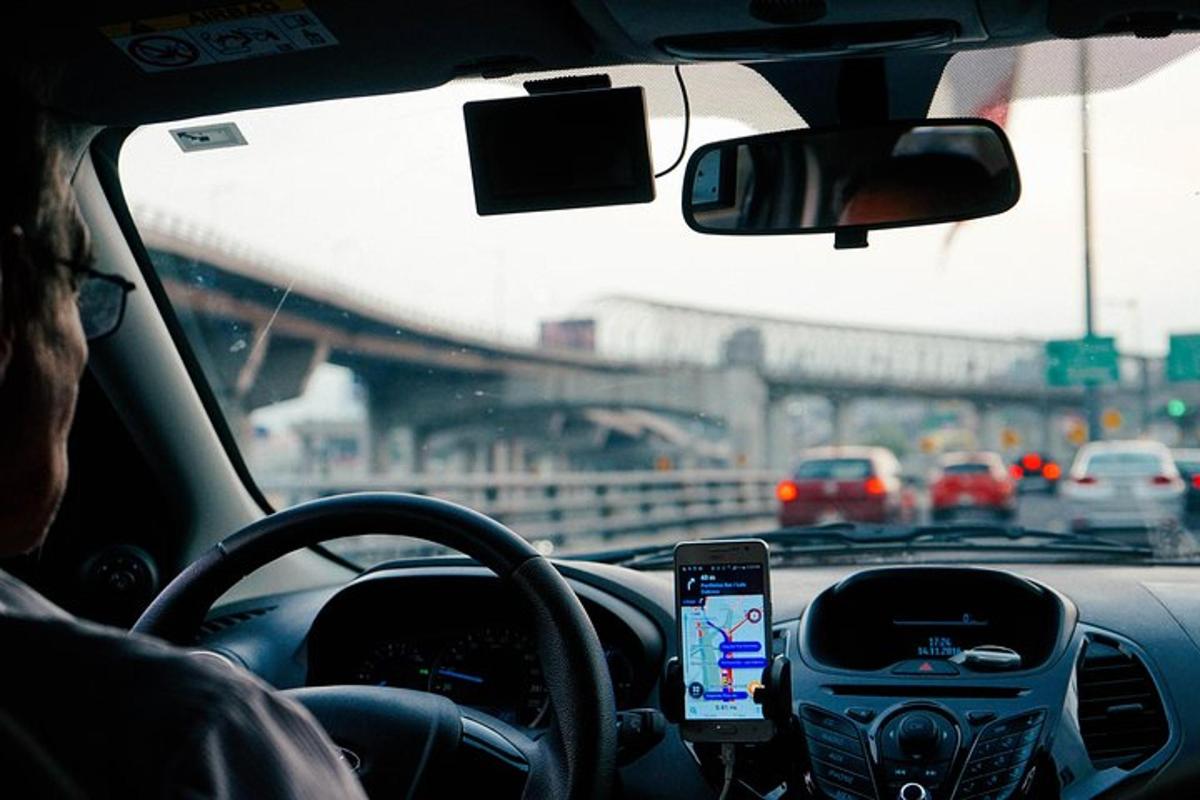 osoba šoférujúca auto s mobilným telefónom