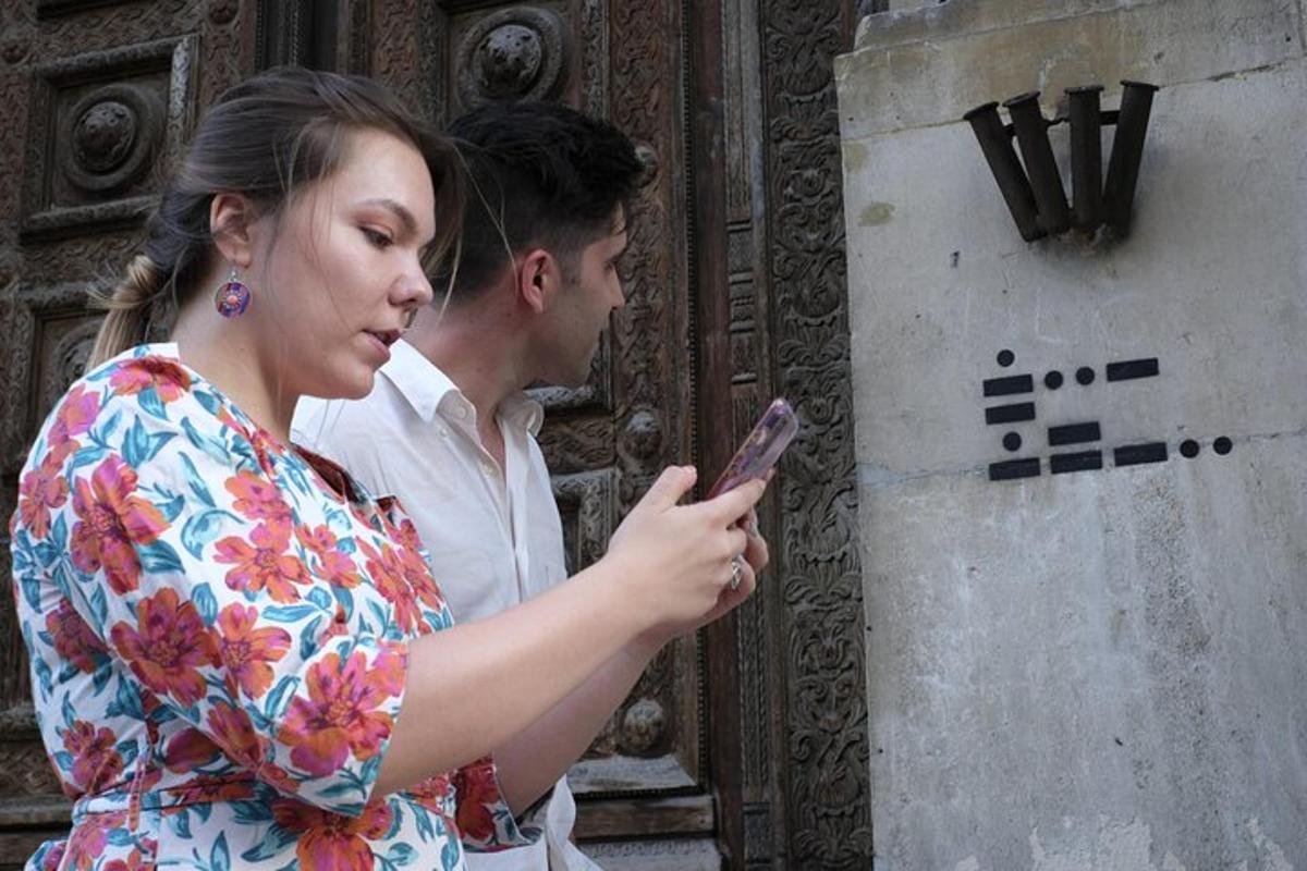 egy férfi és egy nő nézi a mobiltelefonját