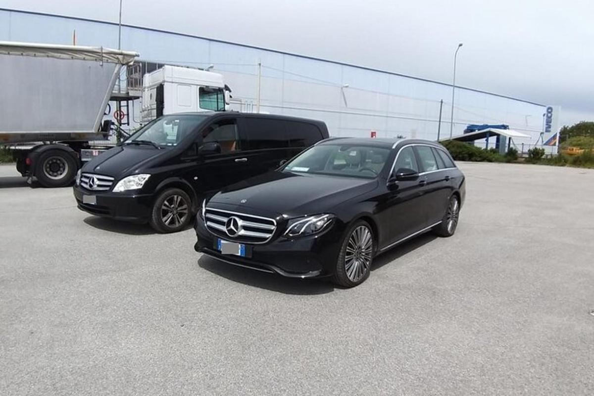 two black cars parked next to a truck