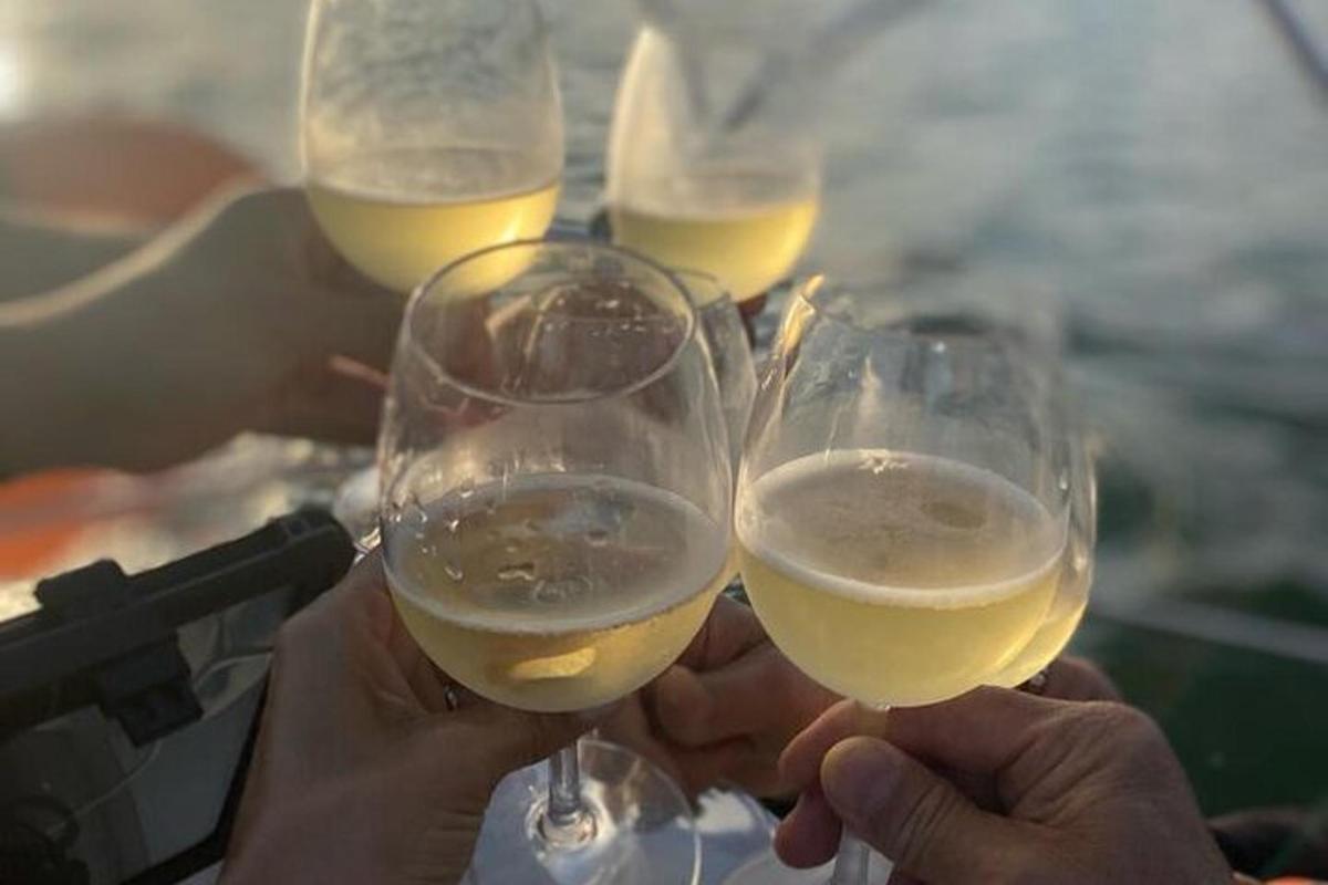 một nhóm người đang cầm ly rượu vang trắng