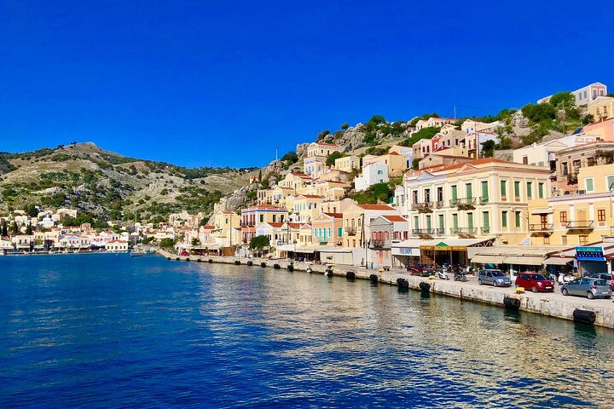 a group of buildings on a hill next to a body of water