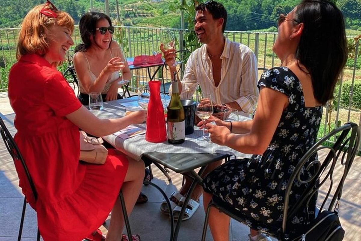 un gruppo di persone sedute a un tavolo che bevono vino