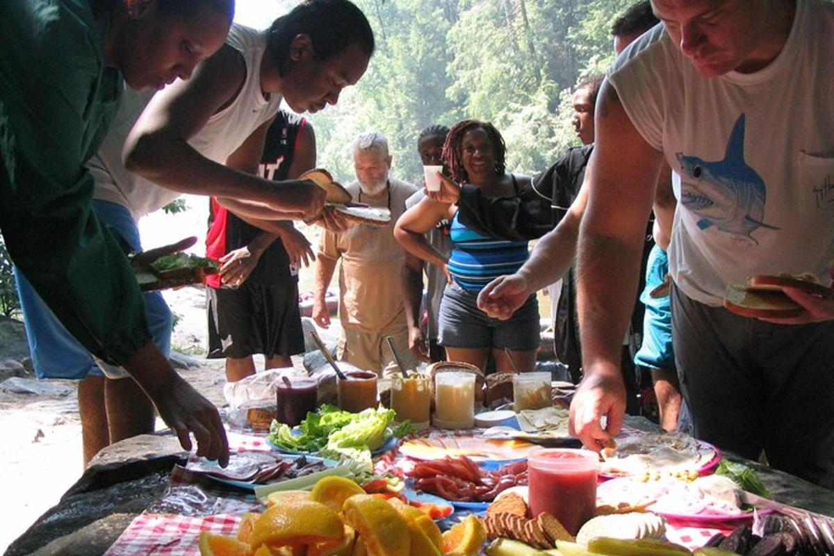 a group of people standing around a table with food