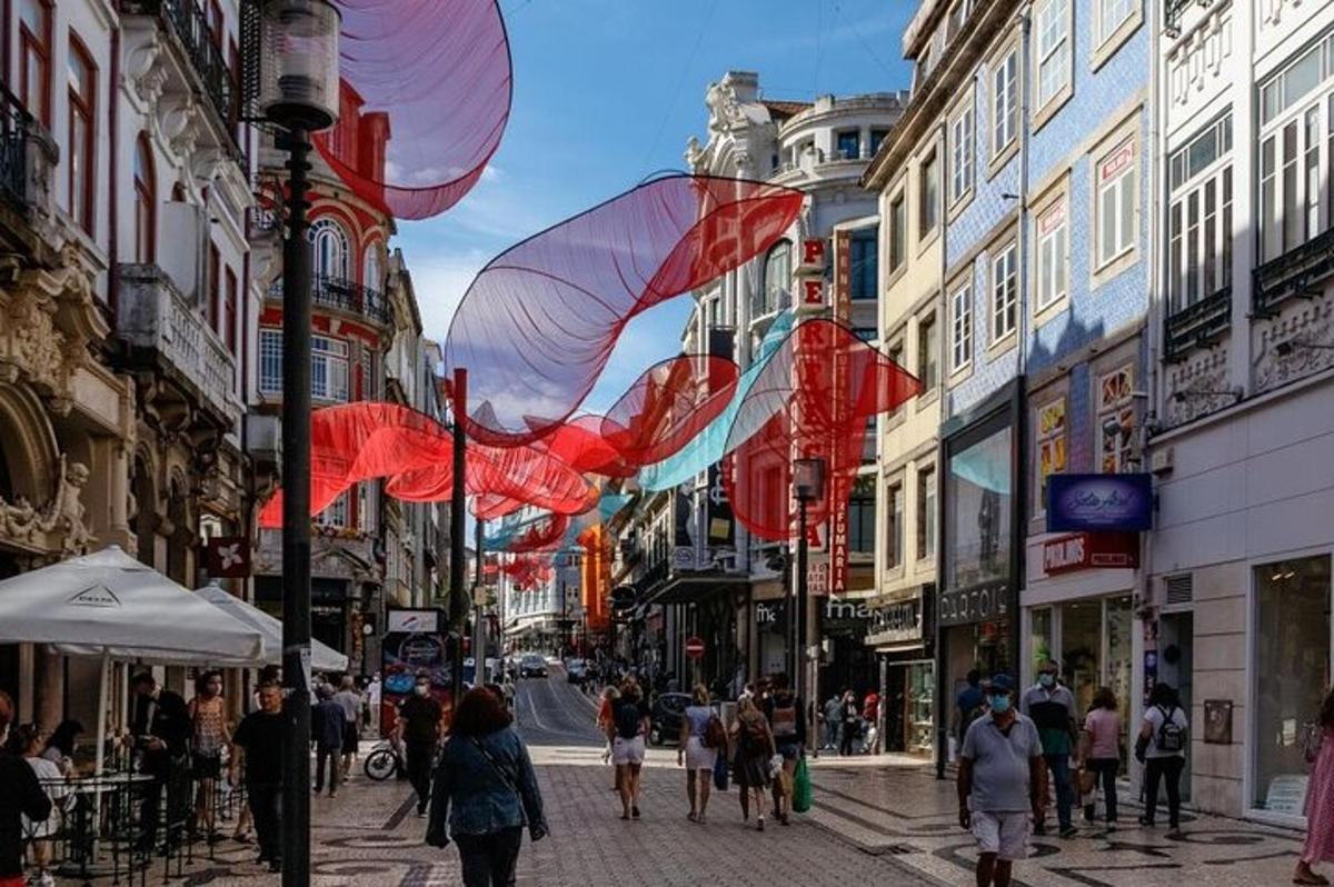 a group of people walking down a city street with red umbrellas