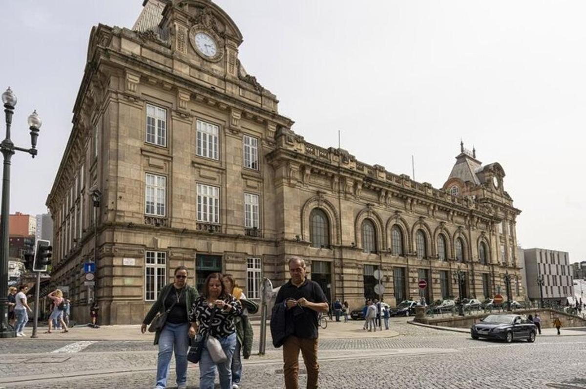 un gruppo di persone che camminano davanti a un edificio con un orologio