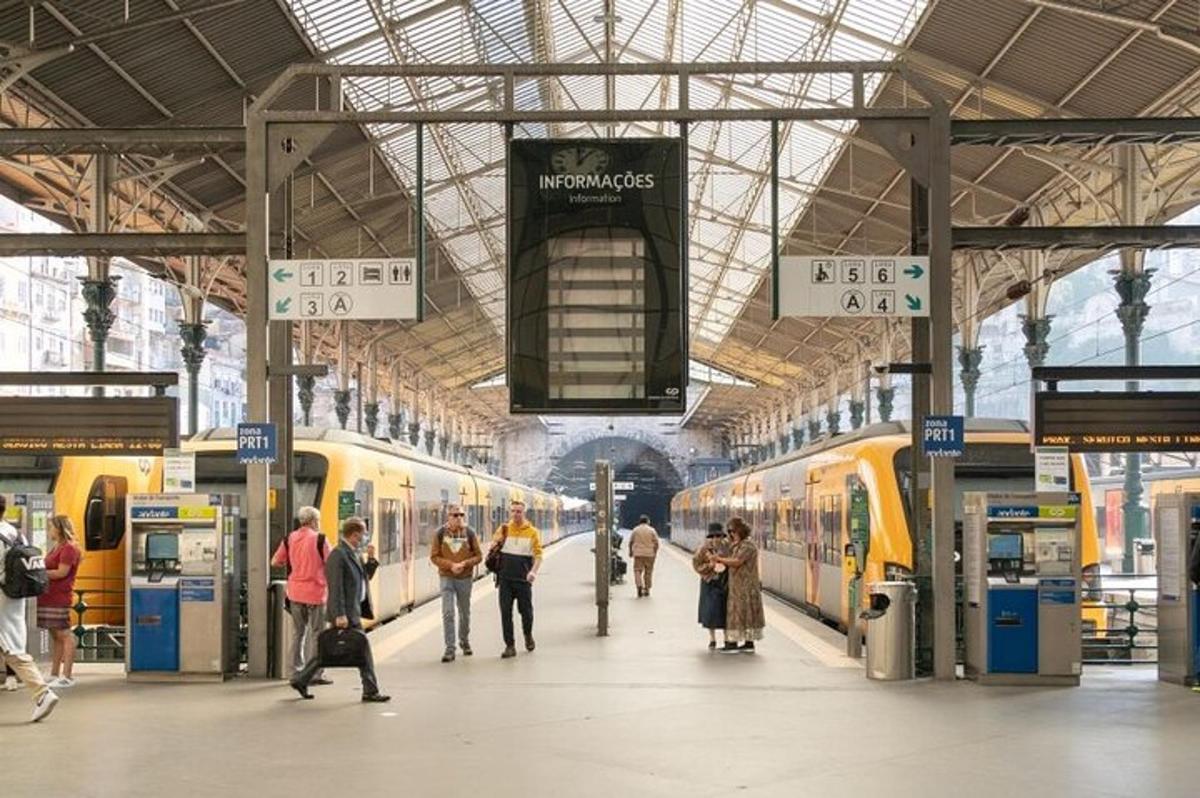una stazione ferroviaria con persone che camminano tra due treni