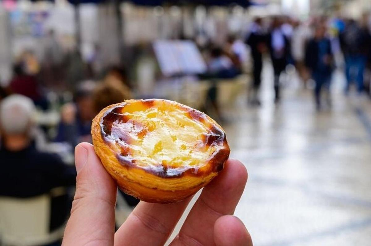a person holding a small pastry in their hand