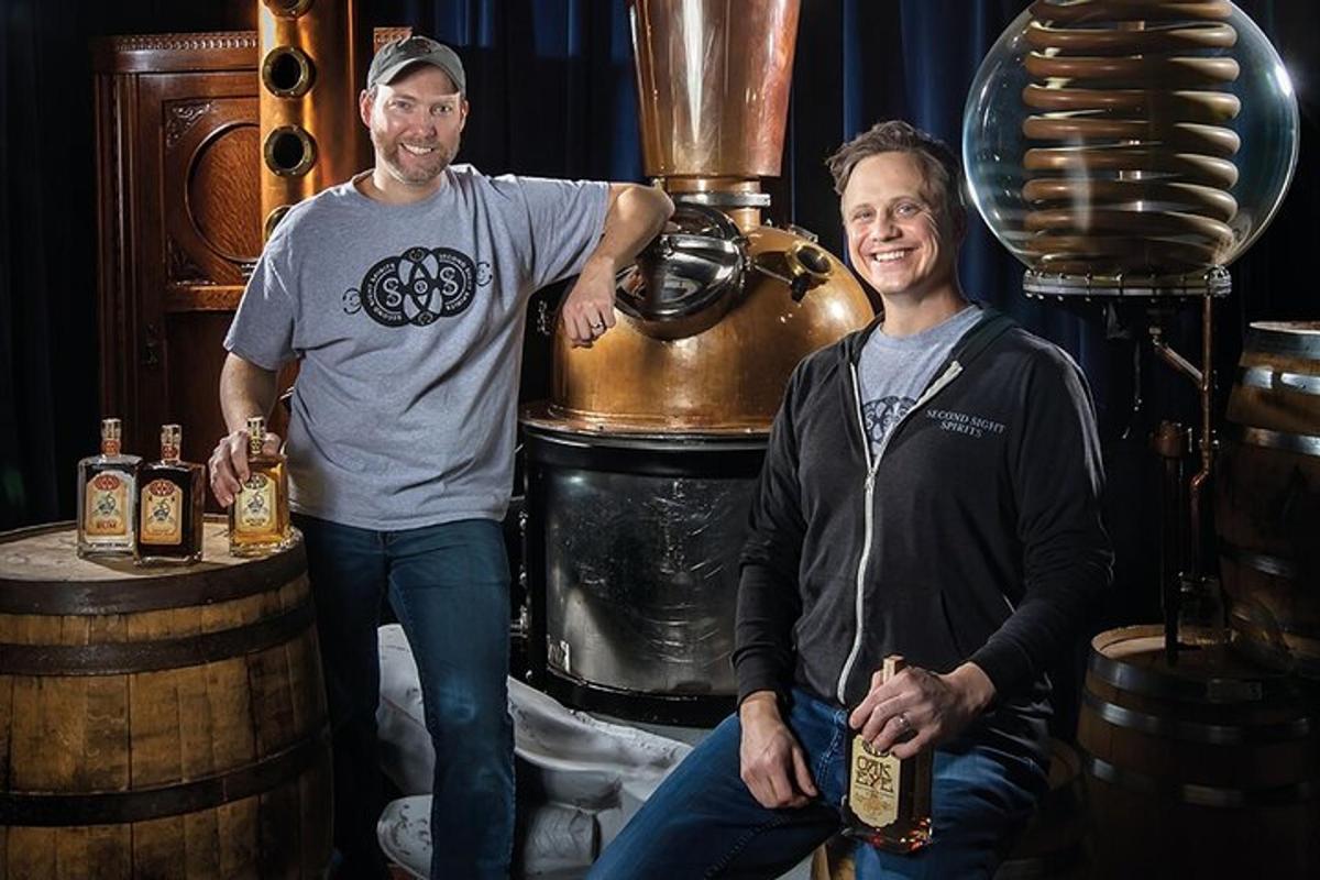 two men are standing next to a beer barrel