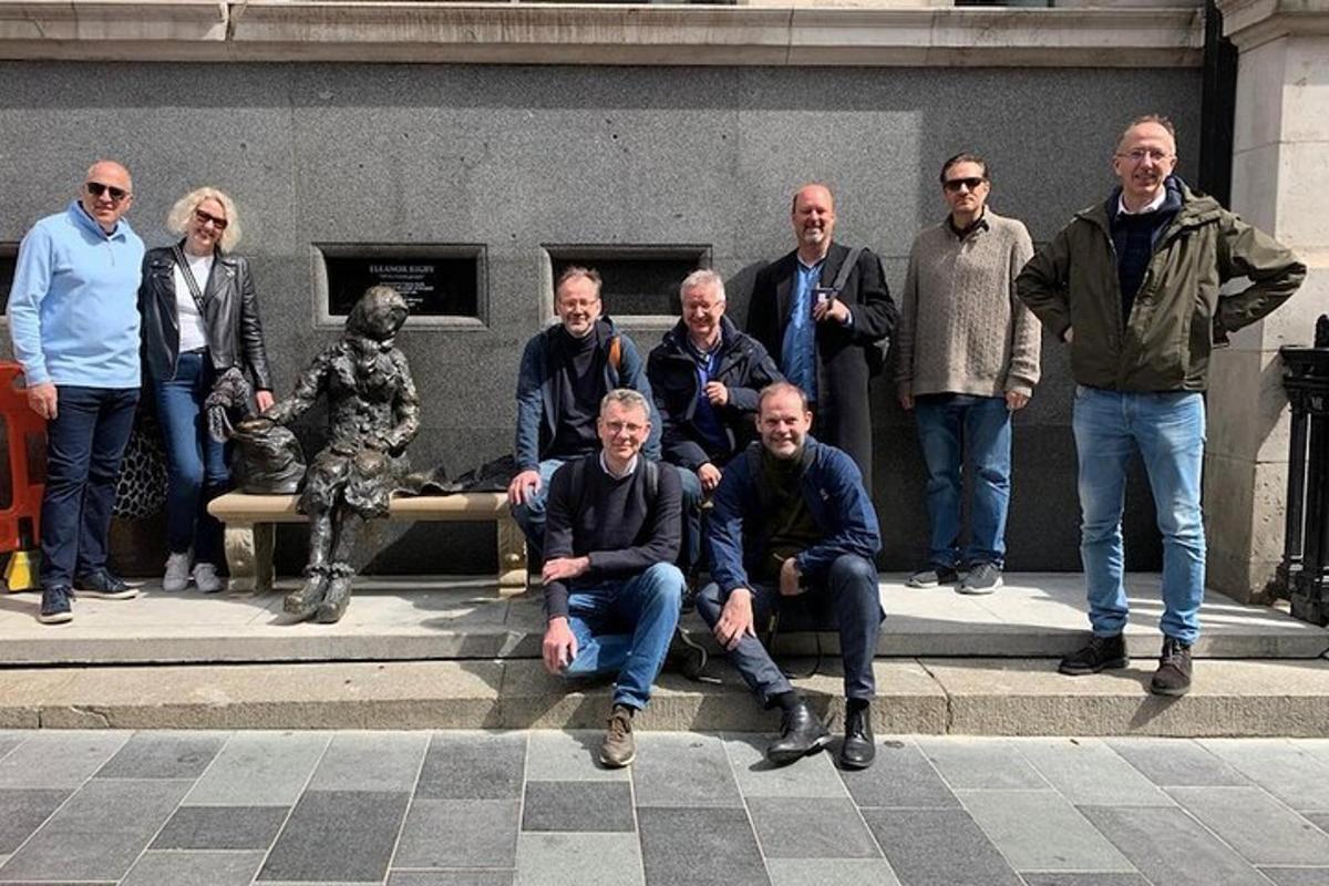 een groep mannen die poseren voor een standbeeld