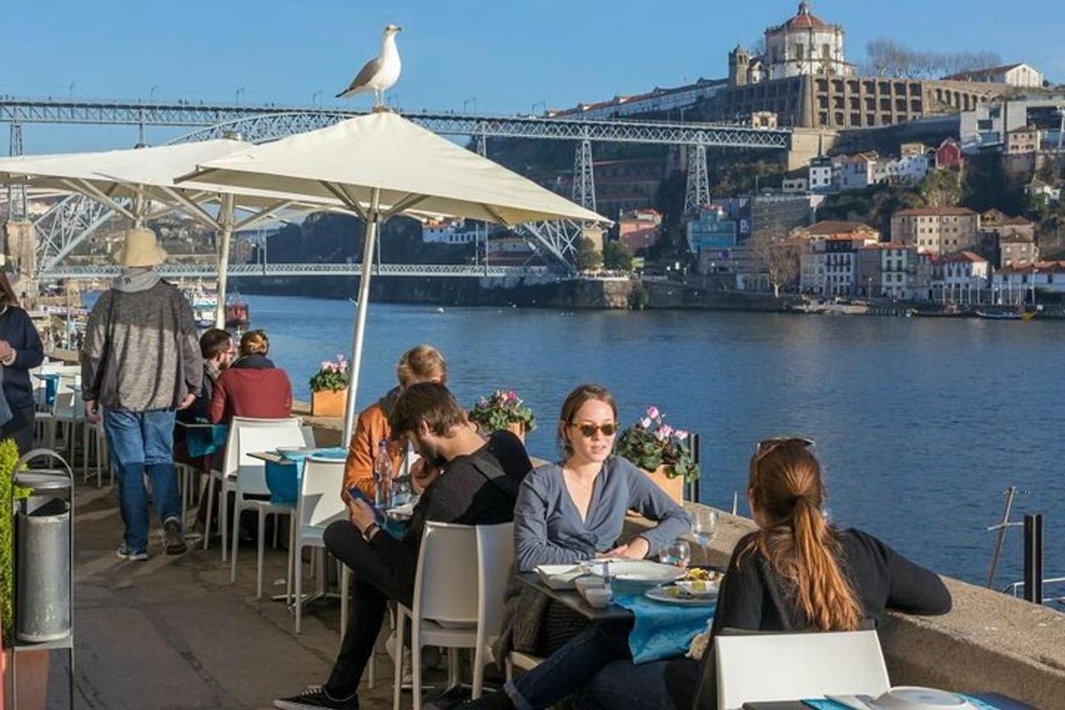 skupina lidí sedících u stolů u vody