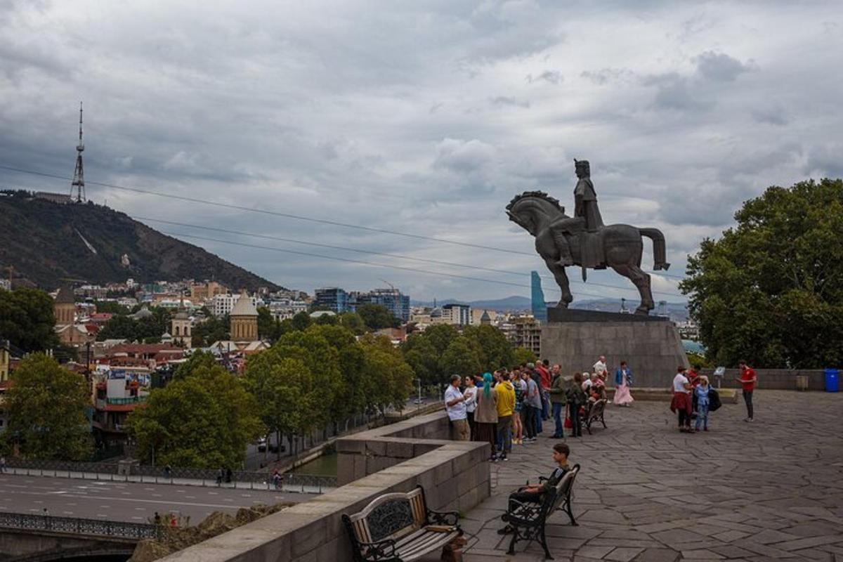 un gruppo di persone in piedi davanti a una statua