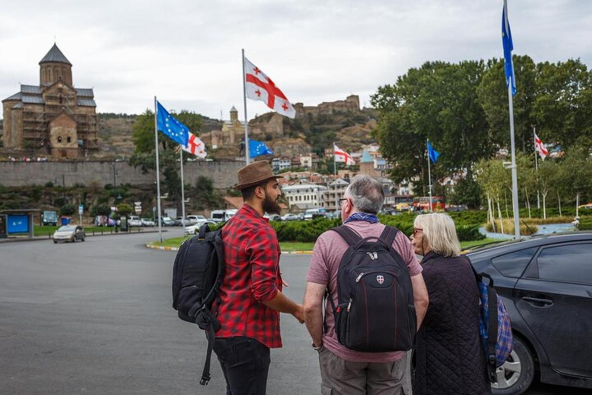 un gruppo di persone che camminano lungo una strada con le bandiere