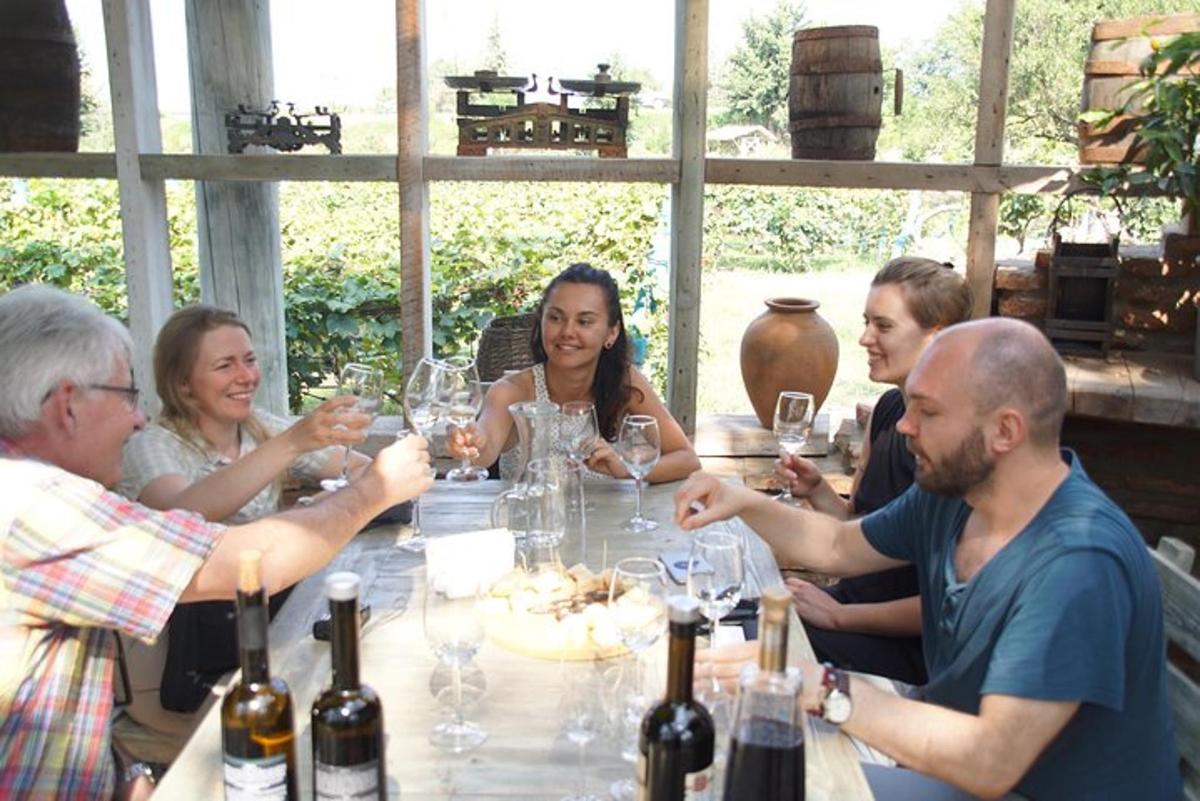 en gruppe mennesker som sitter rundt et bord med vinglass