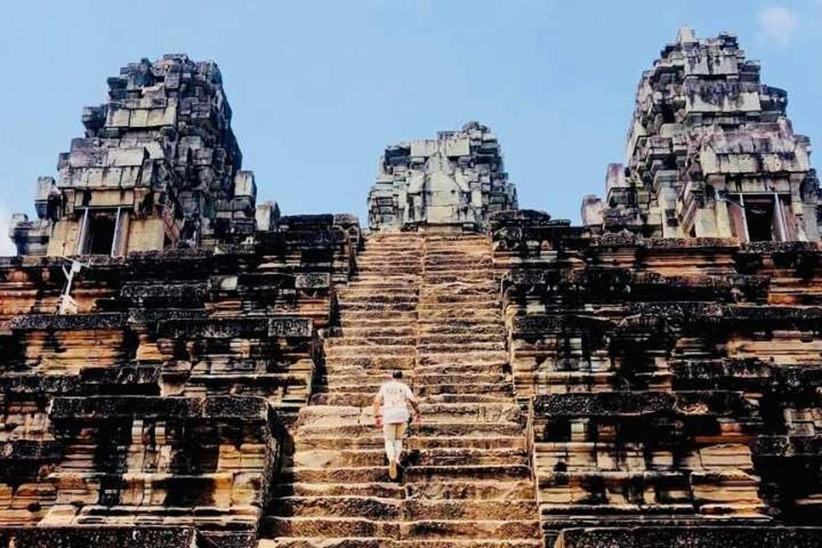 một người đàn ông đang bước lên cầu thang của một ngôi đền cổ