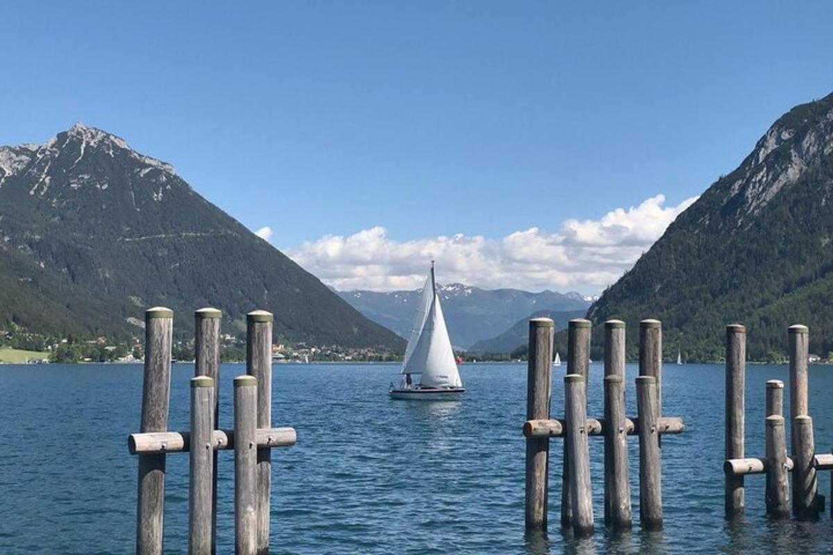una barca a vela in acqua con una barca in lontananza