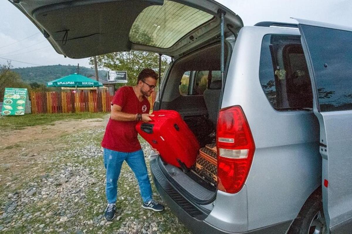 a man putting a surfboard into the back of a van