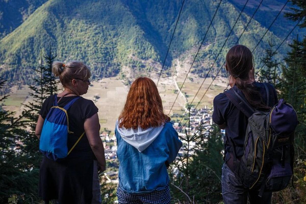 three women standing on a mountain looking at a valley