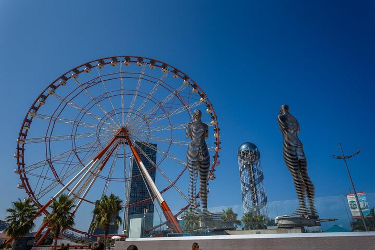 a ferris wheel and two statues in front