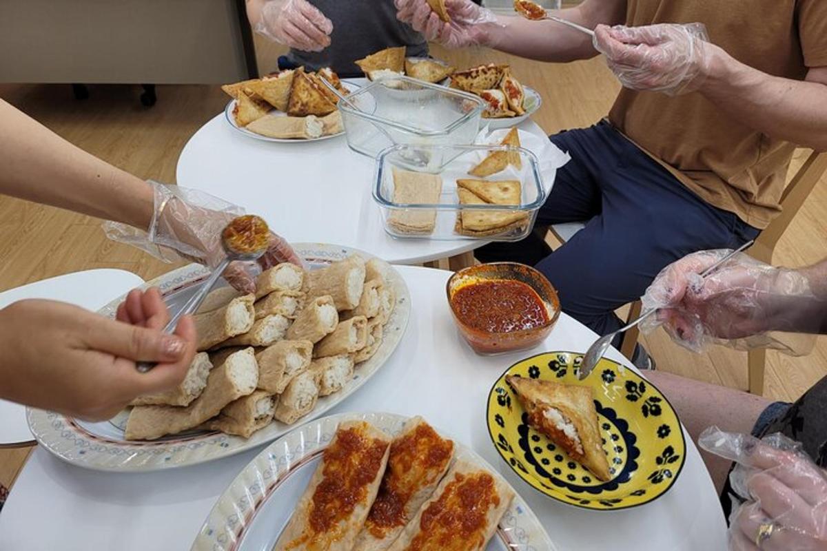 un gruppo di persone sedute attorno a un tavolo con piatti di cibo