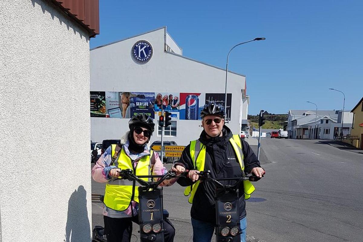two men in yellow vests standing next to a building