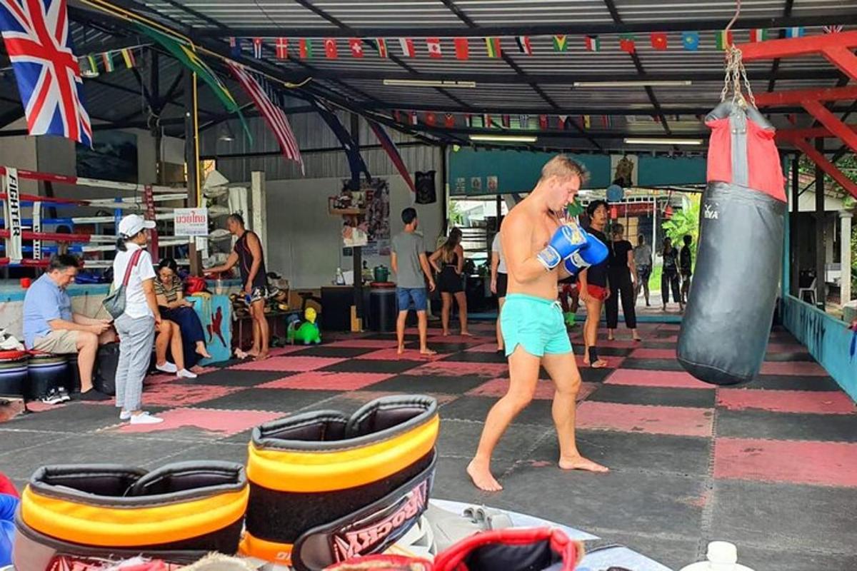 muž stojící v tělocvičně s boxovacím pytlem