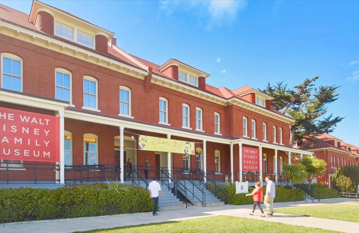 people walking in front of a large brick building